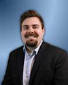 A person in a suit  AI-generated content may be incorrect.